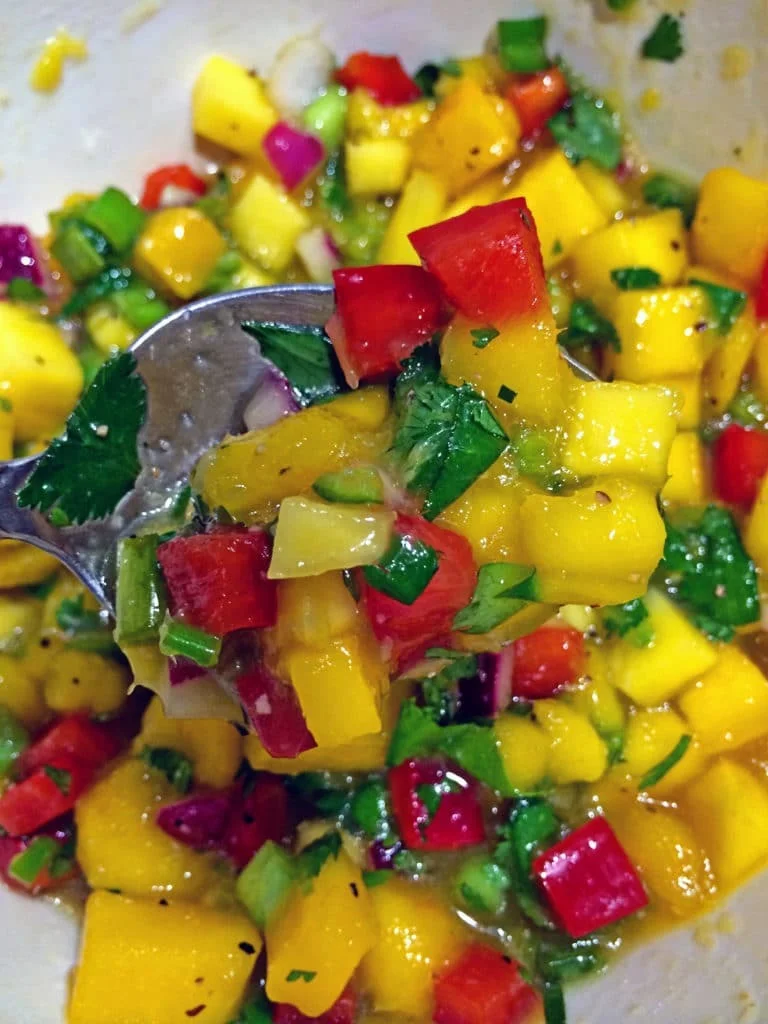 Fresh mango salsa with diced red bell pepper, jalapeño and cilantro in bowl