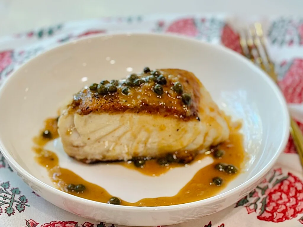 Perfectly cooked sea bass fillet showing flaky texture and golden crispy skin